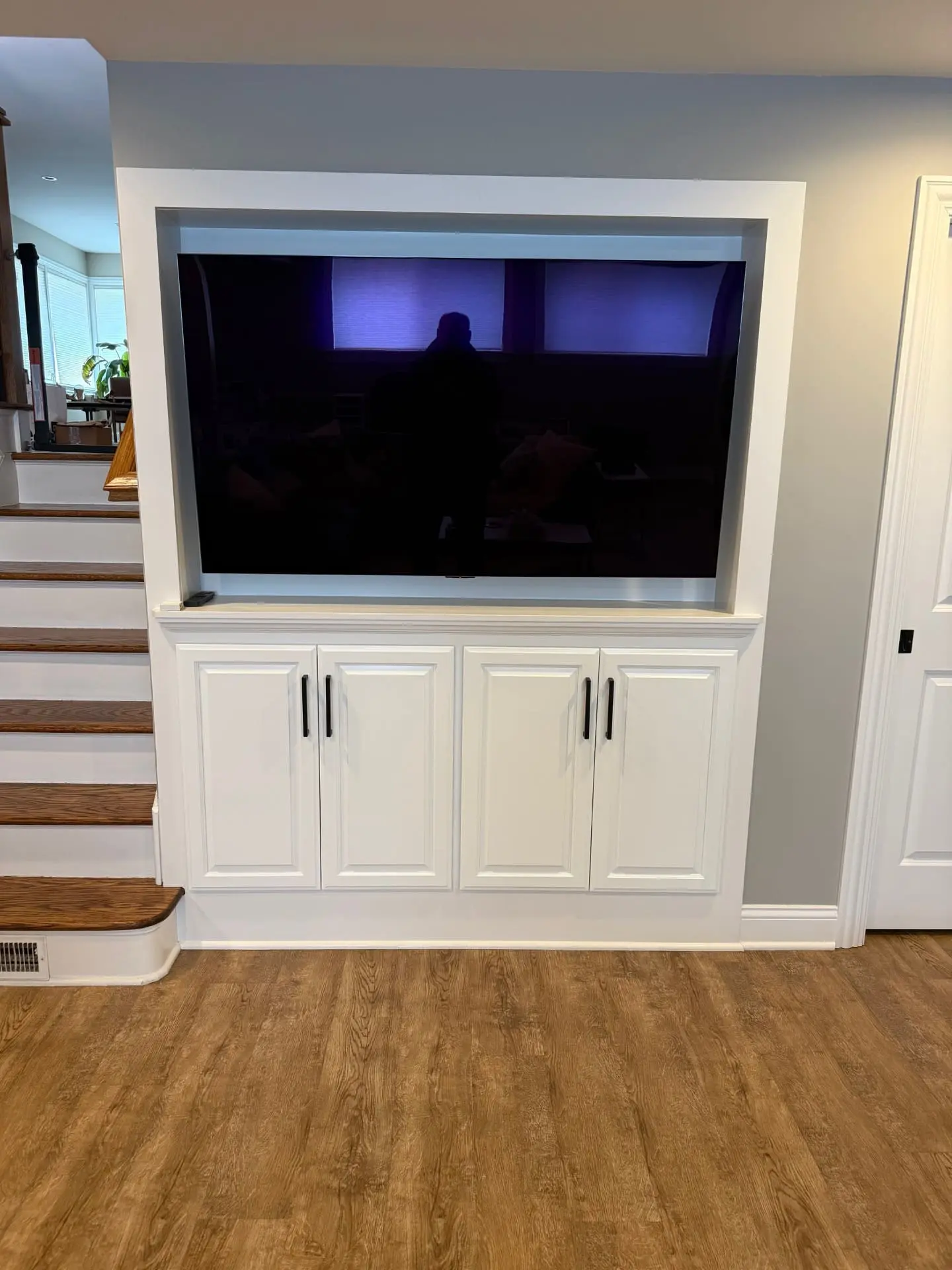 Custom raised-panel entertainment center doors installed in the Elmhurst Tuxedo Park subdivision with matching paint, center support frame, and new handles.