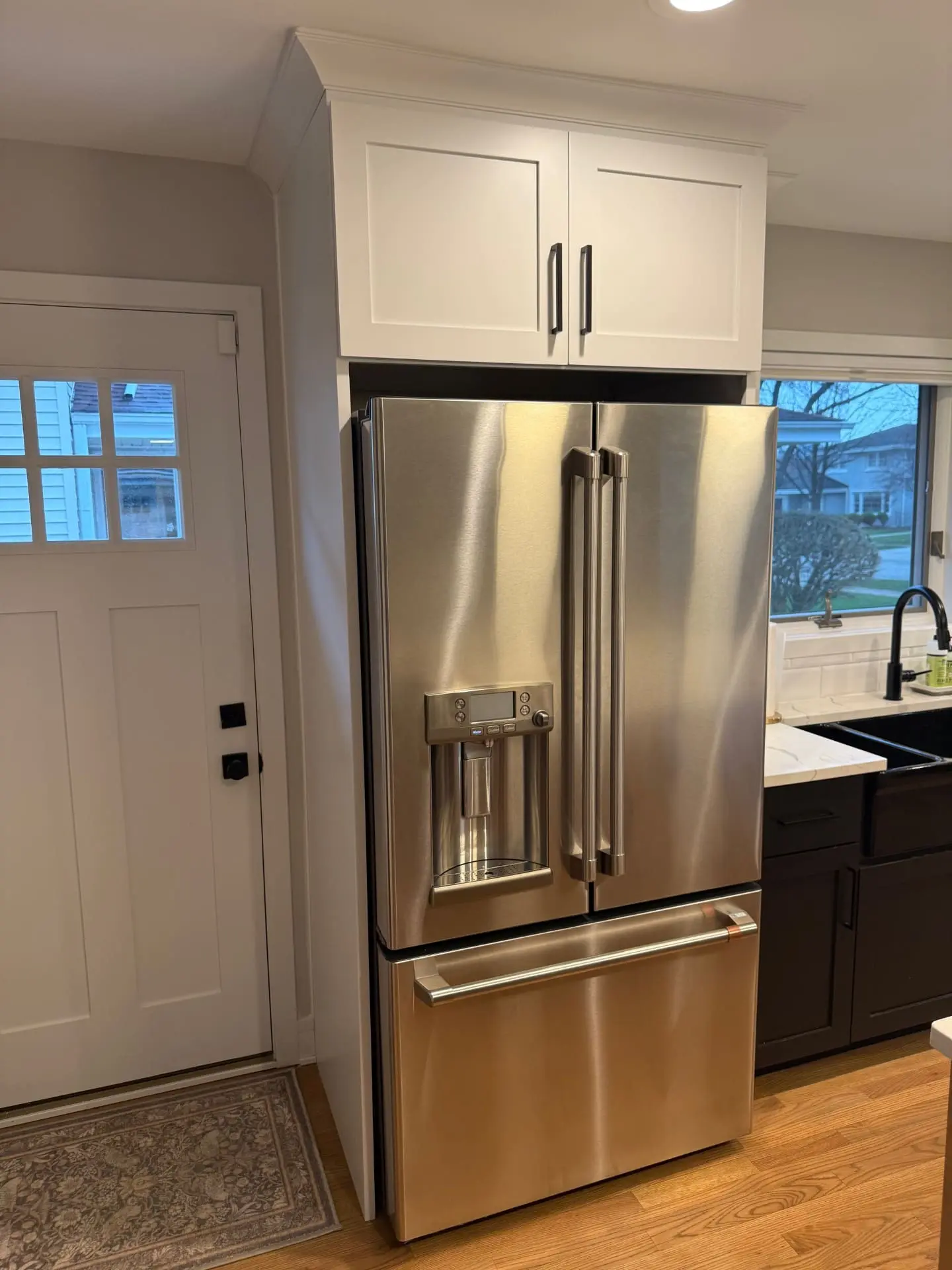 Refrigerator cabinet replacement near Visitation Catholic Church in Elmhurst with a custom-built cabinet, reattached crown molding, and seamless kitchen cabinetry match.